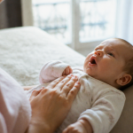 bébé qui grogne et racle la gorge allongé