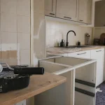 Rénover sa cuisine sans changer les meubles : crédence, façades et poignées noires.